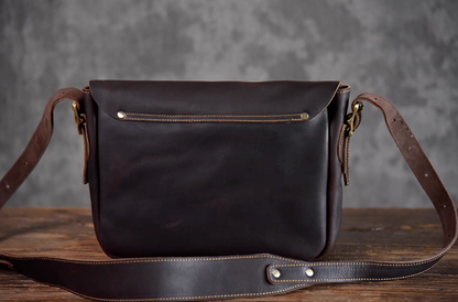 Back view of the dark chocolate leather messenger bag with rear slip pocket and adjustable strap.