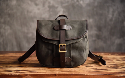 Front view of Olive Green Nomad waxed canvas satchel with leather buckle strap.