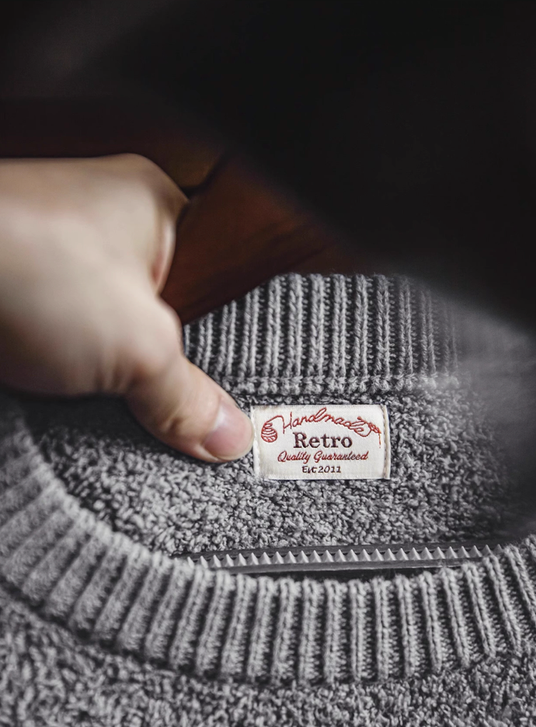 Close-up of retro “Handmade Quality Guaranteed” label inside sweater neckline