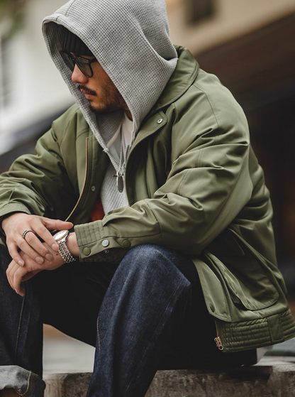 Model seated in Army green Flight Jacket 074 with hoodie layer