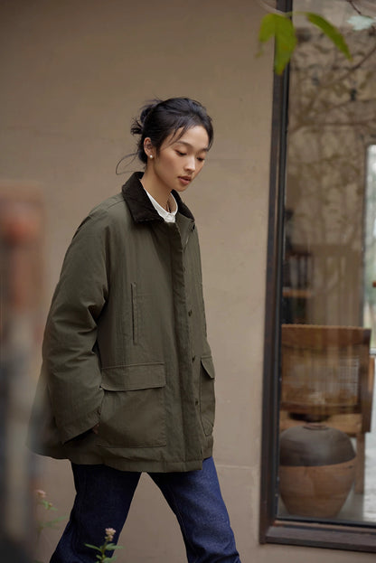Side view of model wearing army green outdoor down jacket walking outside.