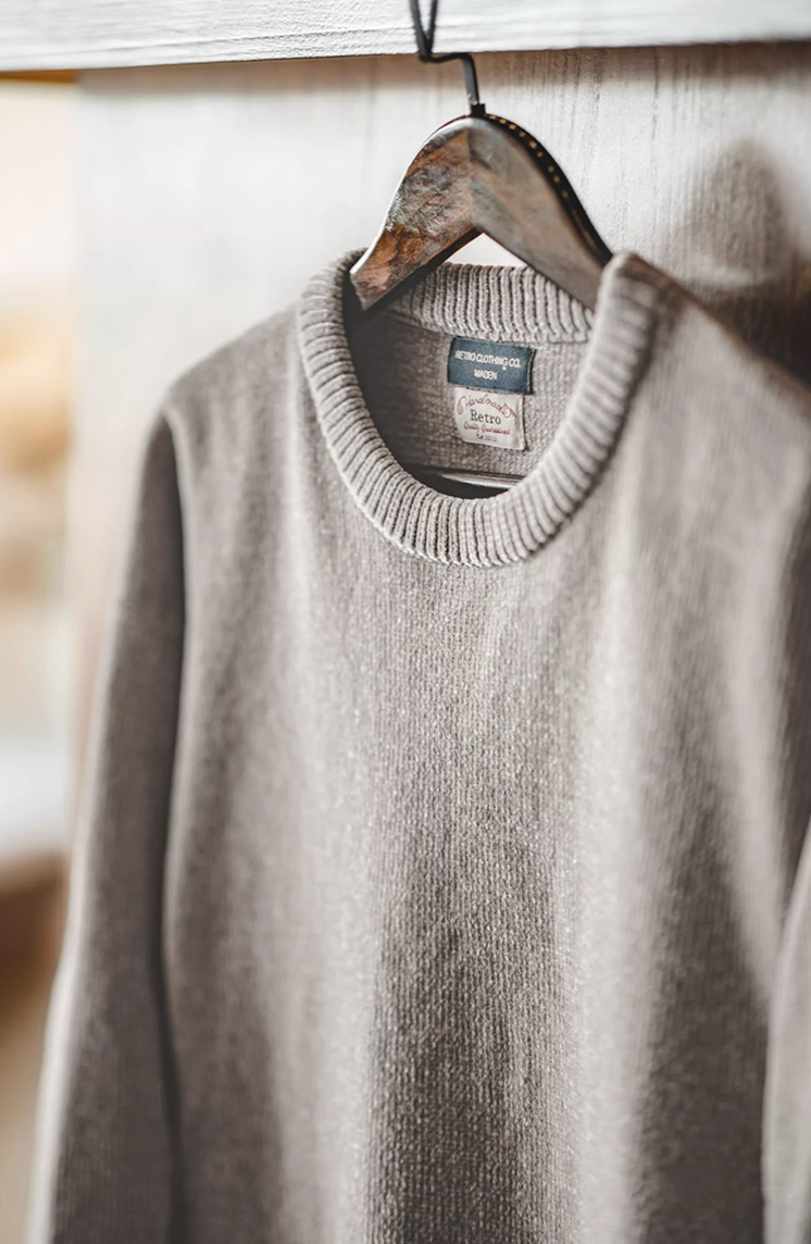 Close-up of light gray chenille sweater showing texture and ribbed crew neckline