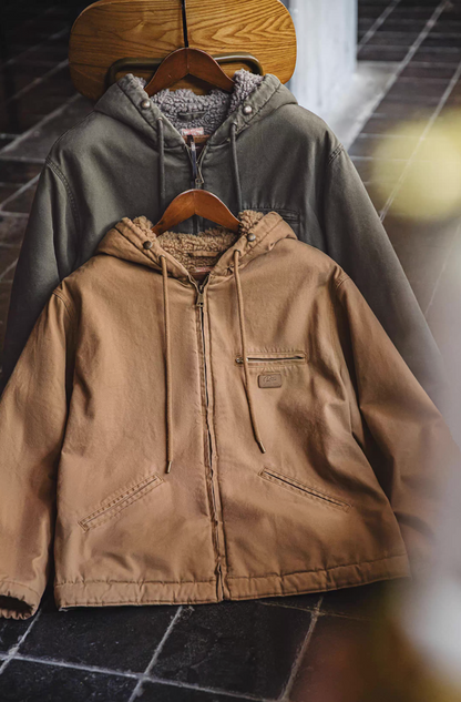 Khaki and dark green sherpa-lined jackets hanging on wooden hangers