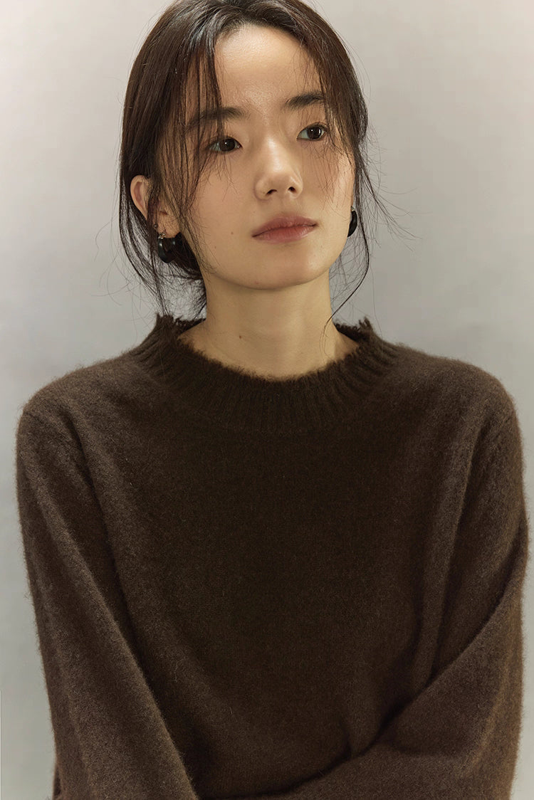 Close-up of dark brown yak wool sweater texture with fine rib neckline.