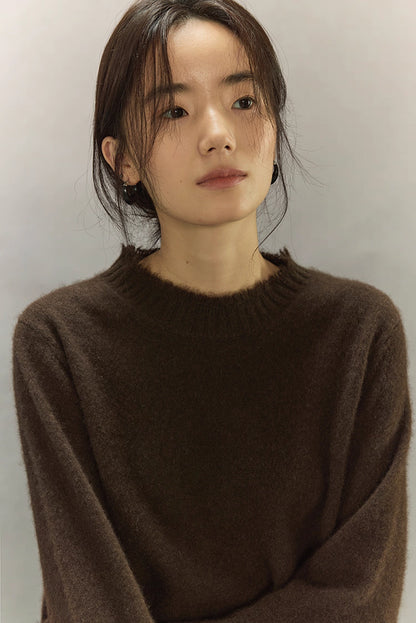 Close-up of dark brown yak wool sweater texture with fine rib neckline.