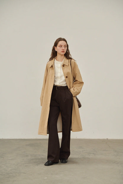 Full body view of beige khaki trench coat with relaxed A-line cut.