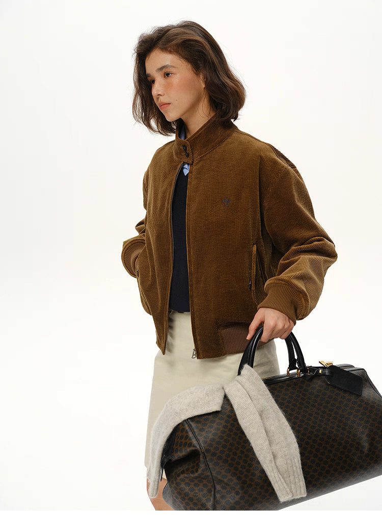 model wearing corduroy stand-collar jacket carrying large weekender bag
