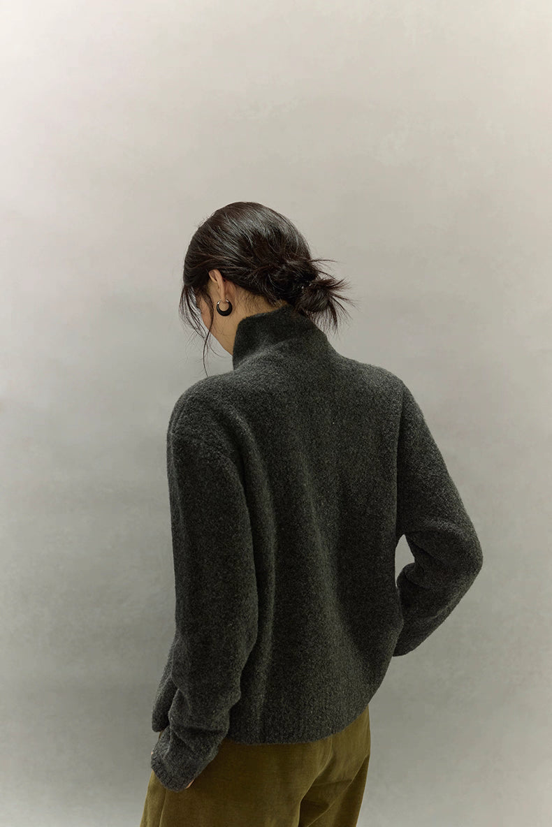 Rear full view of dark charcoal wool high-neck cardigan showing relaxed shape and elegant back drape.