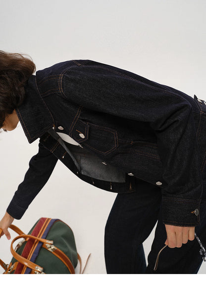 woman bending forward while wearing dark indigo cropped denim jacket