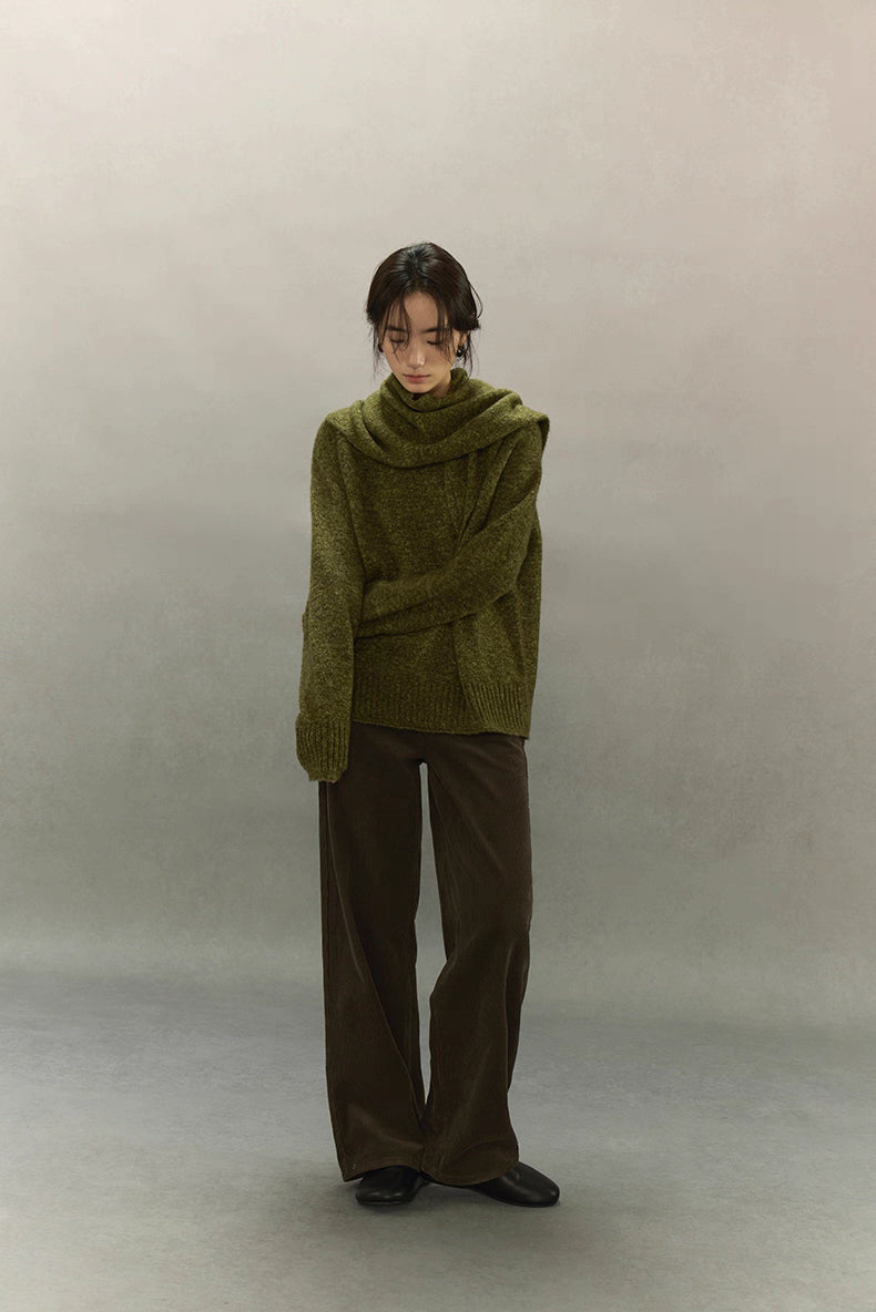 Full-length image of model wearing moss green sweater and wide-leg trousers, minimal winter outfit.