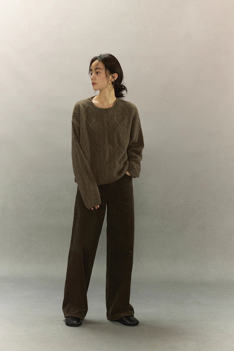 Full-body view of model in yak wool diamond knit sweater and dark brown pants.