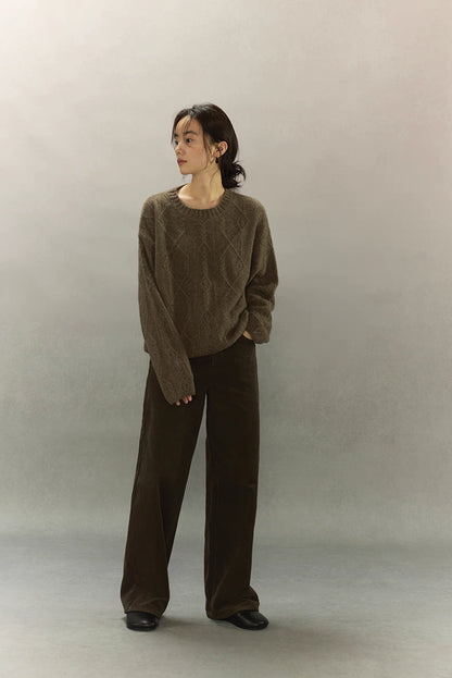 Full-body view of model in yak wool diamond knit sweater and dark brown pants.