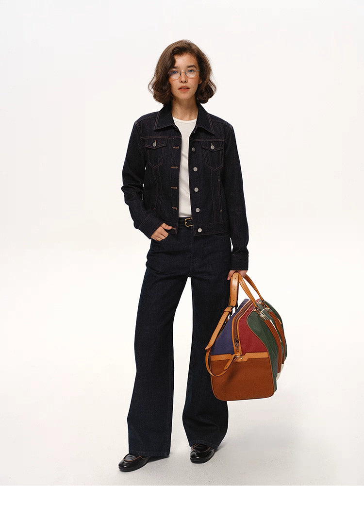 woman standing straight in dark indigo denim jacket and matching jeans