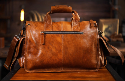 Rear view of camel brown leather duffle with zippered pocket and top handles