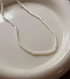 Classic pearl silver necklace single strand flat lay on ceramic plate featuring fine small freshwater pearls on delicate silver chain