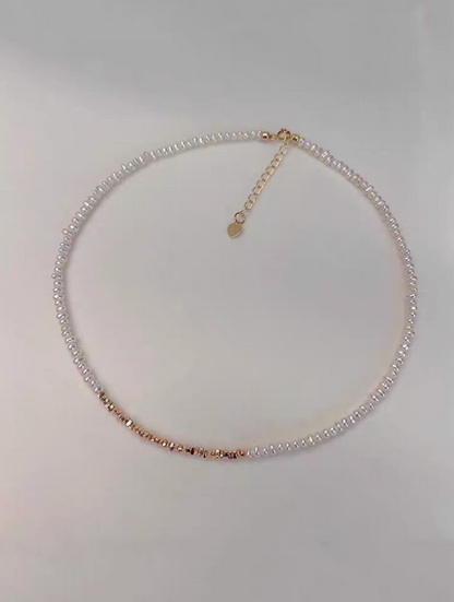 Delicate pearl strand necklace with gold-plated silver accents flat lay showing natural freshwater pearls with gold fragment details and adjustable chain