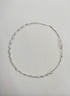 Nature’s Grace baroque pearl branch necklace full view on textured background showing asymmetrical pearl and silver branch design
