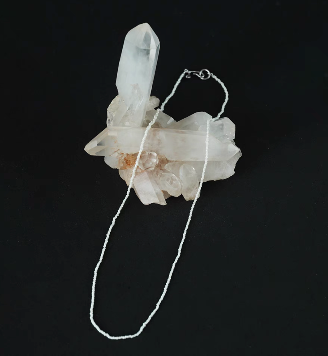 Wild pearl silver choker flat lay on crystal cluster featuring ultra-fine freshwater pearls with delicate minimalist silver clasp