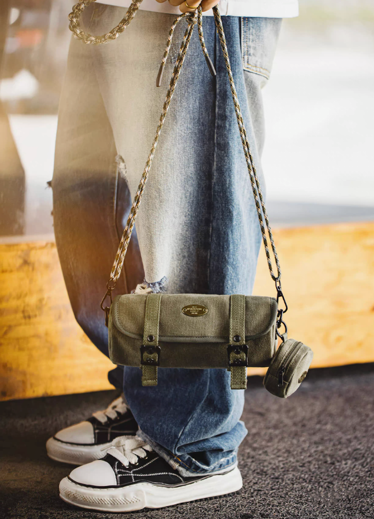 Model styling Ameikaji olive canvas crossbody bag with jeans and sneakers