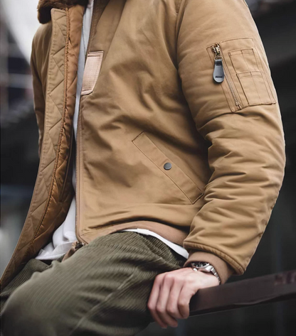 Man sitting outdoors wearing khaki B-15 flight jacket styled with corduroy pants