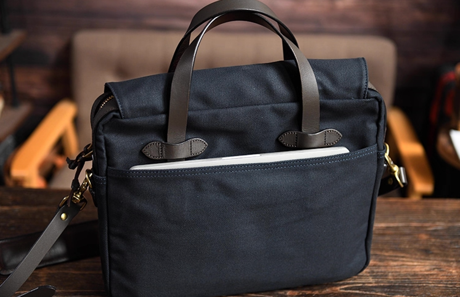 Back pocket design of navy waxed canvas laptop bag showing tablet storage
