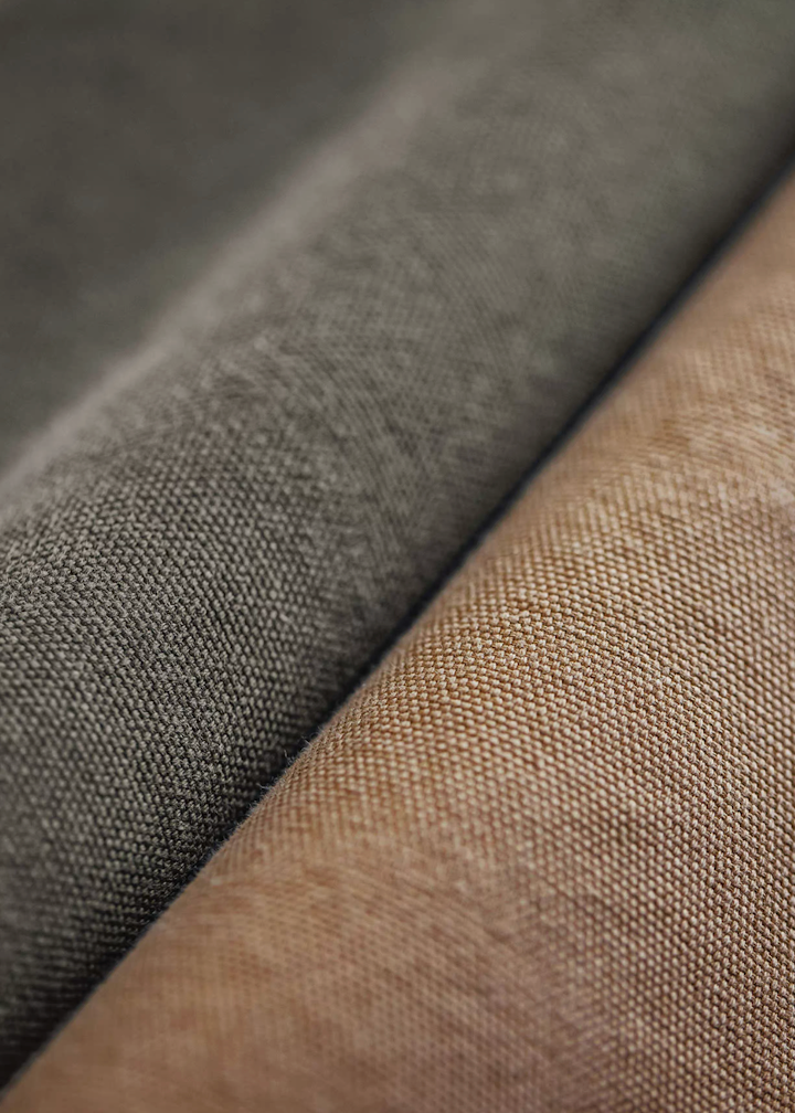 Close-up of rugged washed cotton canvas fabric in khaki and dark green showing weave texture