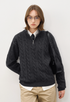Model wearing dark grey half-zip cable knit sweater with tie and beige pants, smart casual look