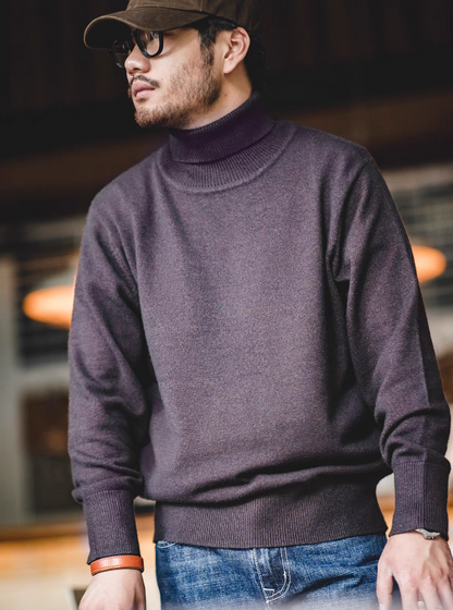Man wearing ash purple turtleneck sweater with jeans and brown cap in warm indoor light