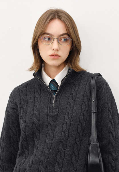 Close-up of unisex dark grey half-zip cable knit sweater with mock neck, paired with shirt and tie