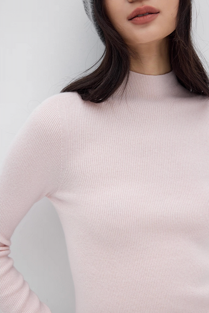 Close-up of light pink cashmere sweater texture with ribbed mock neck, soft luxury knitwear