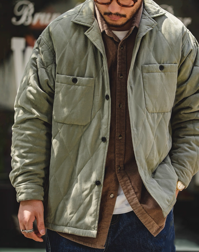 Man wearing army green quilted peach-skin jacket outdoors
