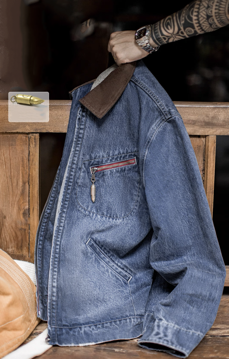 Denim Detroit jacket with brown corduroy collar and brass bullet zipper resting on wooden bench