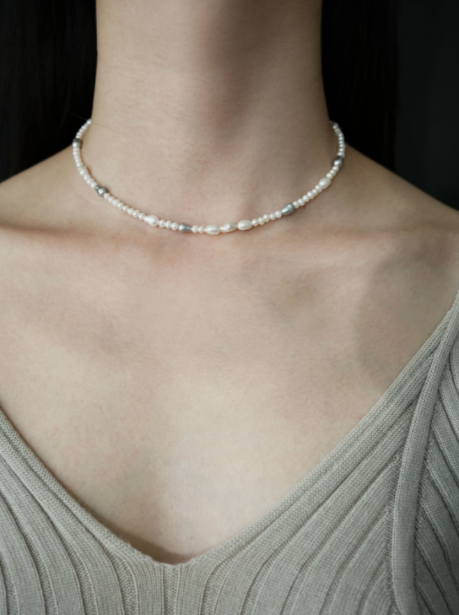 Model wearing elegant baroque pearl choker showcasing irregular freshwater pearls with mixed white and gray tones in a minimalist front view