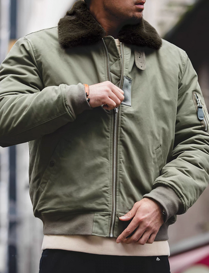 Man zipping up green B-15 bomber jacket showing military style