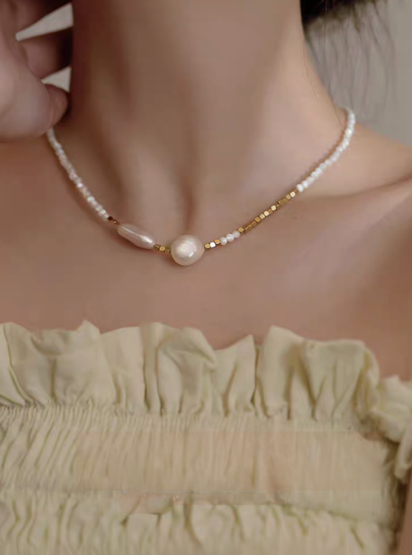 Model wearing Heirloom pearl and shell beaded necklace showing centered baroque pearl and delicate beaded chain