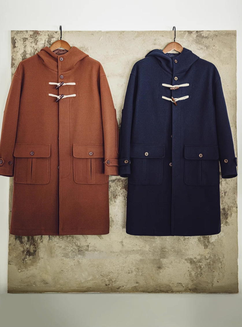 Brown and navy men’s duffle coats hanging side by side