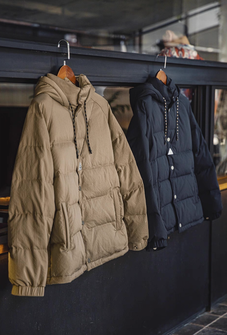 Khaki and dark blue Urban Shield Down Jackets hanging side by side