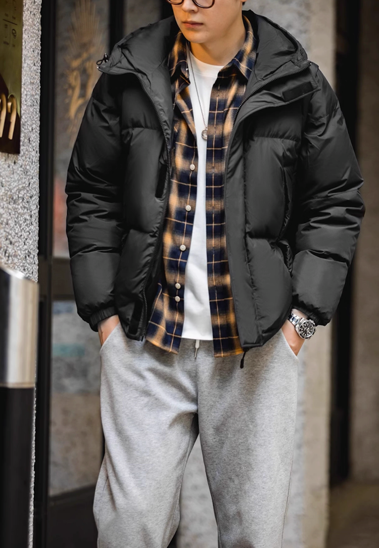 Model wearing black Versatile Parka over plaid shirt and sweatpants