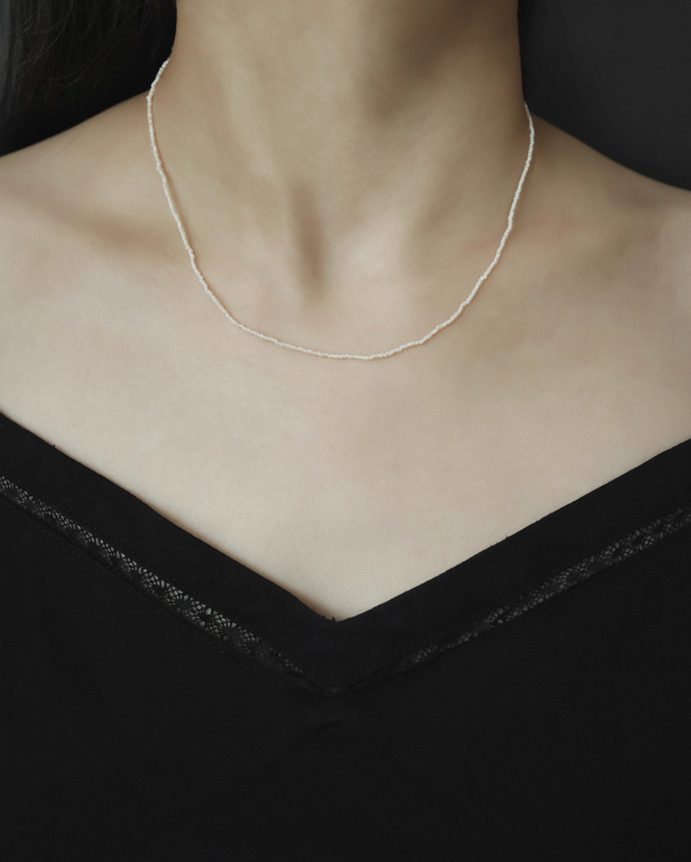 Model wearing wild pearl silver choker featuring ultra-fine freshwater pearls forming a delicate minimalist necklace on neckline