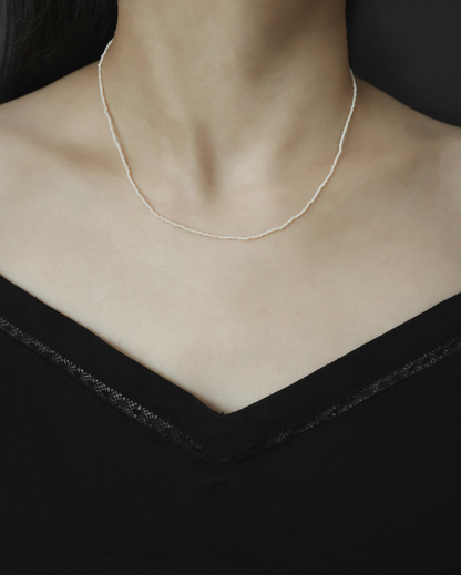 Model wearing wild pearl silver choker featuring ultra-fine freshwater pearls forming a delicate minimalist necklace on neckline