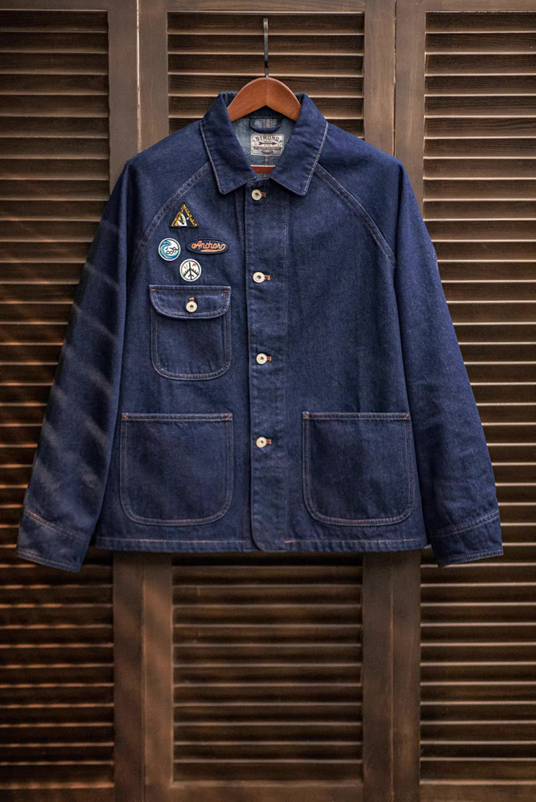 Denim workwear chore coat hanging on wooden hanger