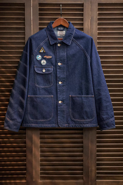 Denim workwear chore coat hanging on wooden hanger