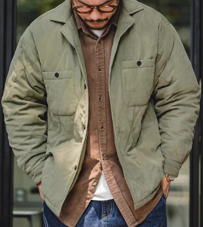 Close-up view of man styling army green quilted jacket