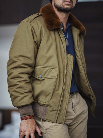 Man wearing olive B-10 flight jacket outdoors, showing brown faux-fur collar and rugged texture.