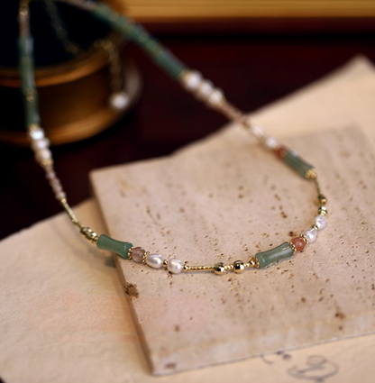 Bamboo pearl necklace with aventurine freshwater pearls and agate flat lay on stone surface highlighting mixed gemstone and pearl design