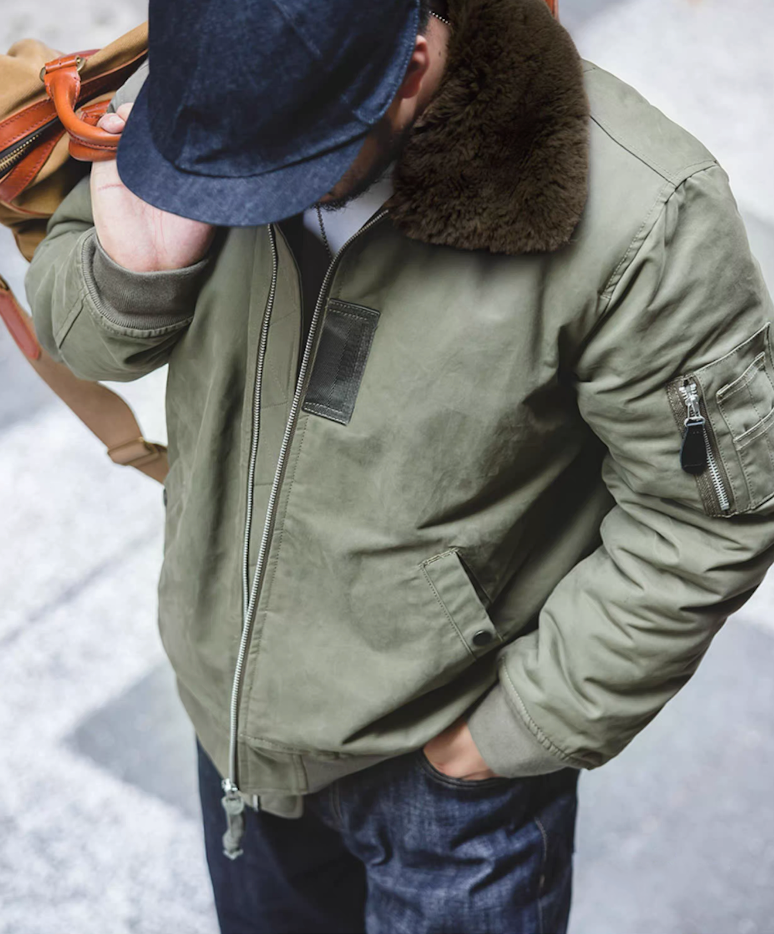 Top angle of green B-15 bomber jacket showing shoulder fit and fur collar
