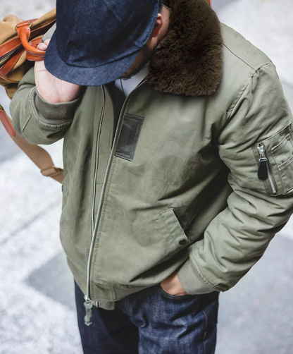 Top angle of green B-15 bomber jacket showing shoulder fit and fur collar