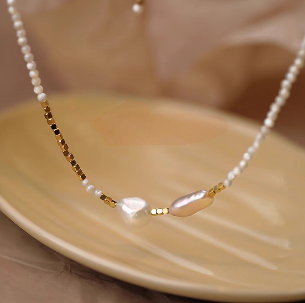 Close-up of Heirloom pearl and shell beaded necklace highlighting baroque pearls, small pearls, and gold bead accents