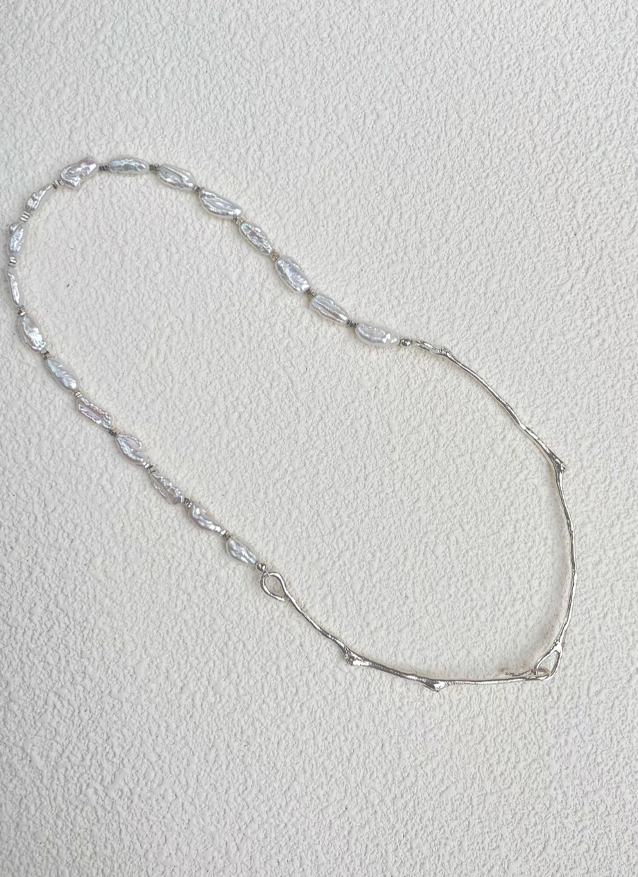 Nature’s Grace baroque pearl branch necklace flat lay highlighting elongated baroque pearls and organic silver branch links