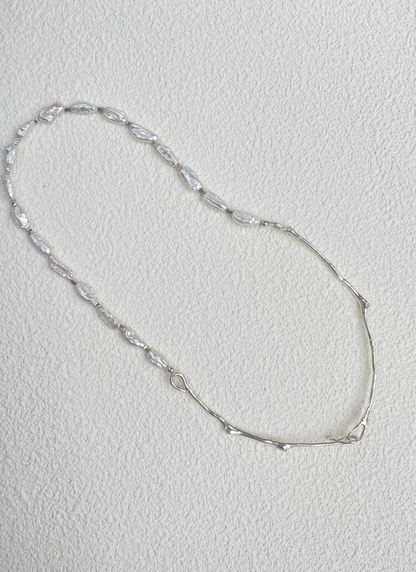 Nature’s Grace baroque pearl branch necklace flat lay highlighting elongated baroque pearls and organic silver branch links